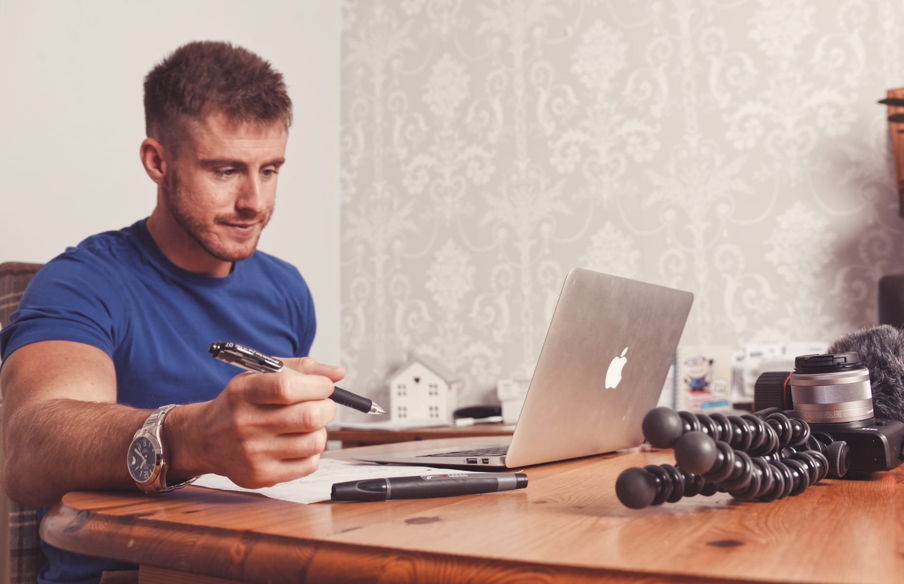 Ash Dykes planning an expedition at a desk with a laptop and camera equipment