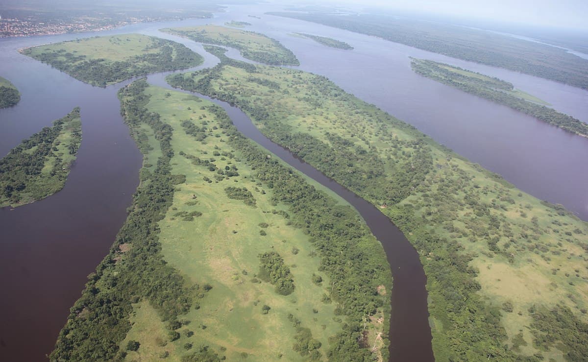 aerial view of a broad river system with multiple green vegetated islands and channels