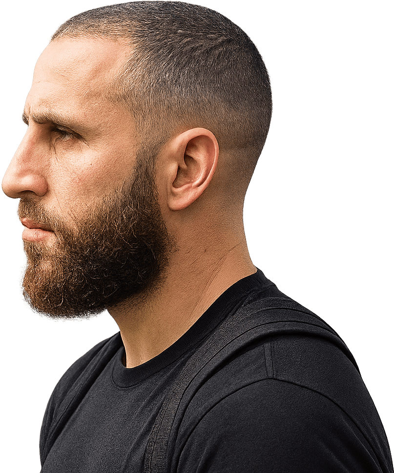 profile portrait of a man with a buzz cut, full beard, and black t-shirt on a white background