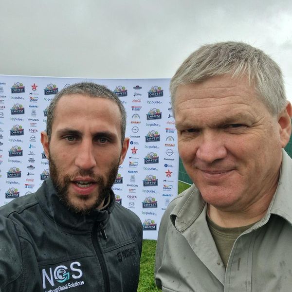 two men posing at a CarFest event sponsor backdrop, one wearing an NGS Northcott Global Solutions branded jacket