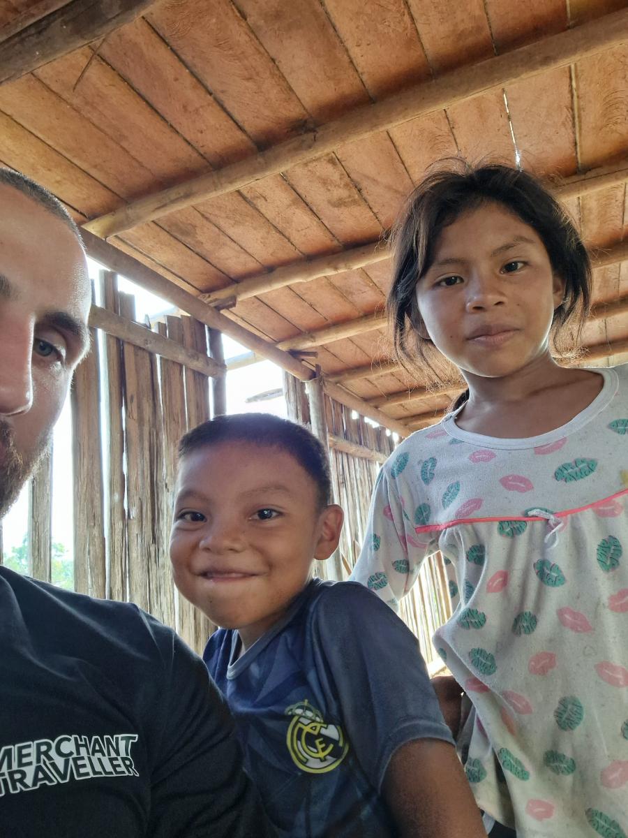 selfie of a man with two children inside a rustic wooden building