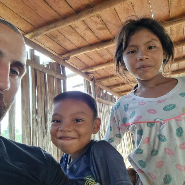 selfie of a man with two children inside a rustic wooden building